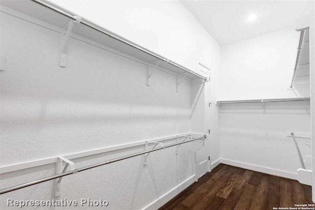 walk in closet with dark wood-type flooring