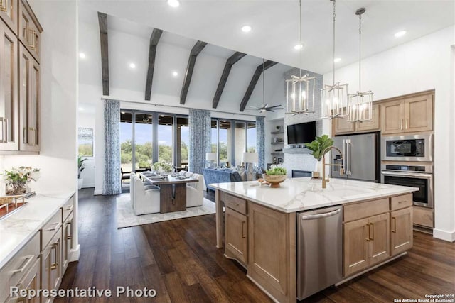 kitchen with hanging light fixtures, dark hardwood / wood-style flooring, an island with sink, stainless steel appliances, and light stone counters