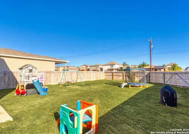 view of yard featuring a playground and a trampoline