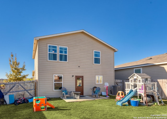 rear view of house featuring central AC unit, a playground, a patio area, and a lawn