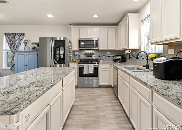 kitchen featuring light stone countertops, sink, and appliances with stainless steel finishes