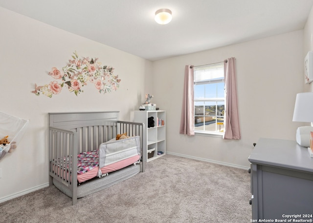 bedroom featuring a nursery area and light colored carpet