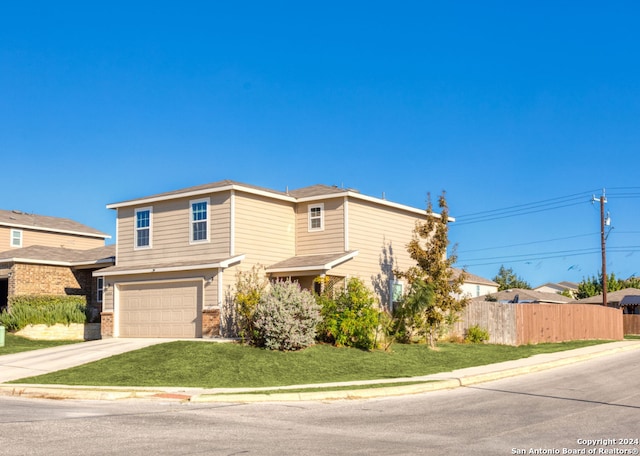 view of property featuring a garage and a front lawn