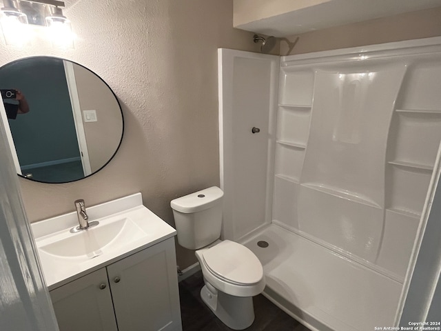 bathroom with a shower, vanity, and toilet