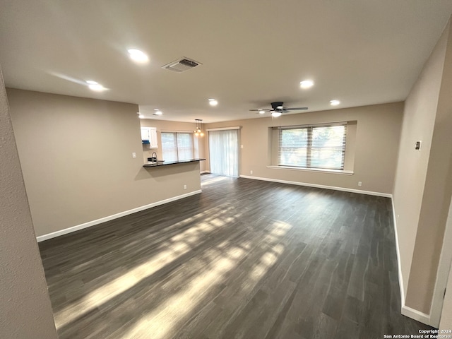 unfurnished living room featuring ceiling fan and dark hardwood / wood-style flooring