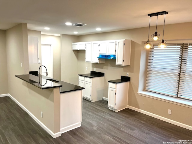 kitchen with kitchen peninsula, sink, pendant lighting, white cabinets, and dark hardwood / wood-style floors