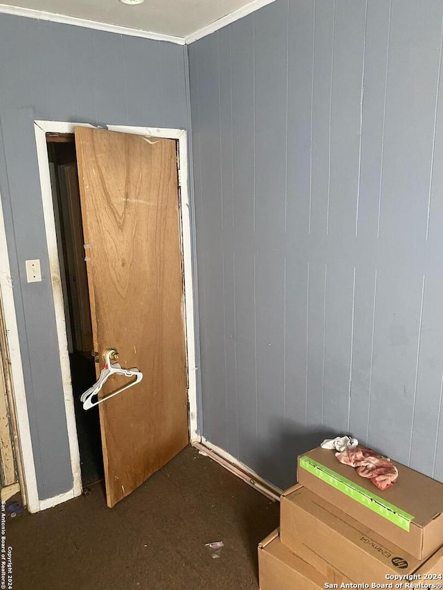 interior space featuring wooden walls and ornamental molding