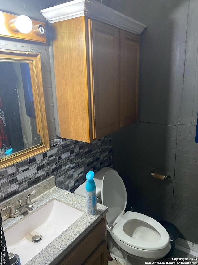 bathroom with vanity, toilet, and backsplash