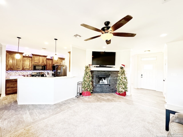 living room with a fireplace, ceiling fan, light hardwood / wood-style flooring, and ornamental molding