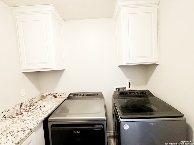 washroom with cabinets and washing machine and dryer