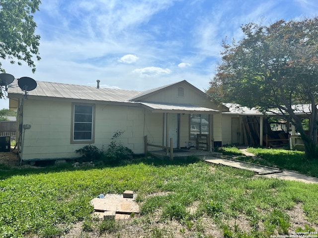 view of front of home featuring central air condition unit and a front lawn