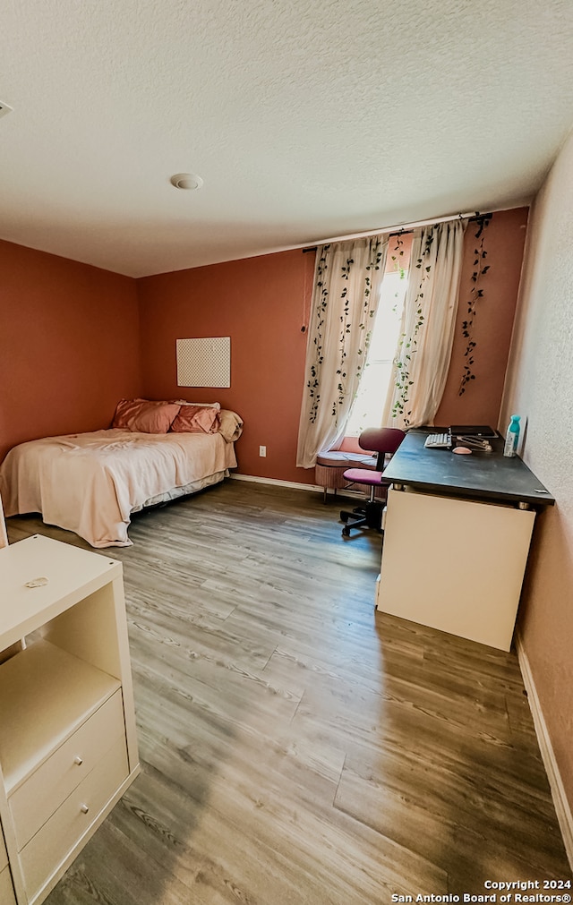 unfurnished bedroom featuring hardwood / wood-style flooring and a textured ceiling