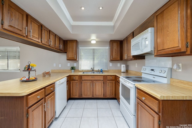 kitchen with white appliances, a raised ceiling, sink, light tile patterned flooring, and kitchen peninsula