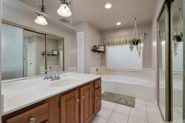 bathroom with tile patterned flooring, vanity, and a tub