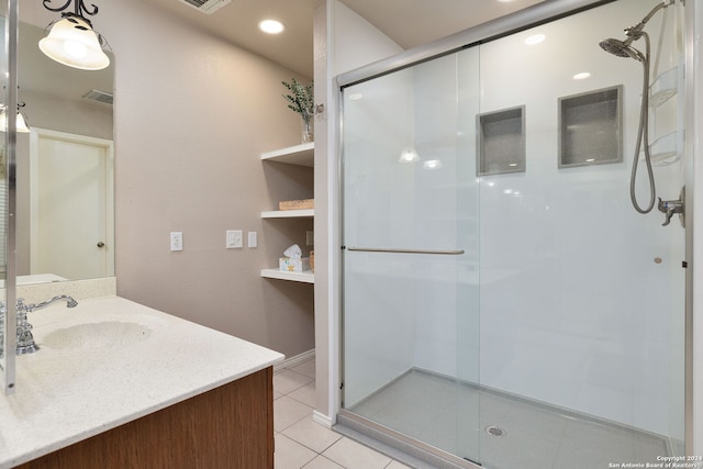 bathroom with tile patterned flooring, vanity, and a shower with shower door