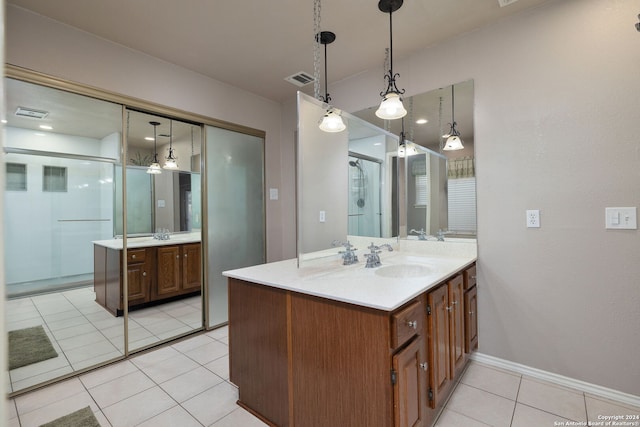 bathroom with tile patterned flooring, vanity, and a shower with shower door