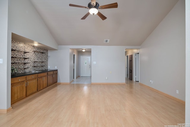 unfurnished living room featuring ceiling fan, lofted ceiling, and light wood-type flooring