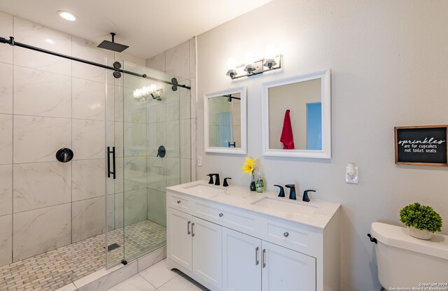 bathroom featuring vanity, a shower with shower door, and toilet