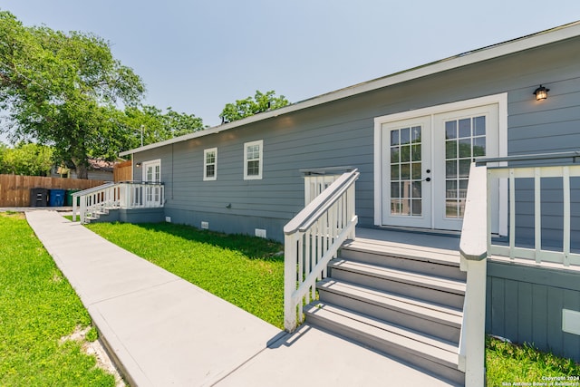 exterior space featuring french doors and a front lawn