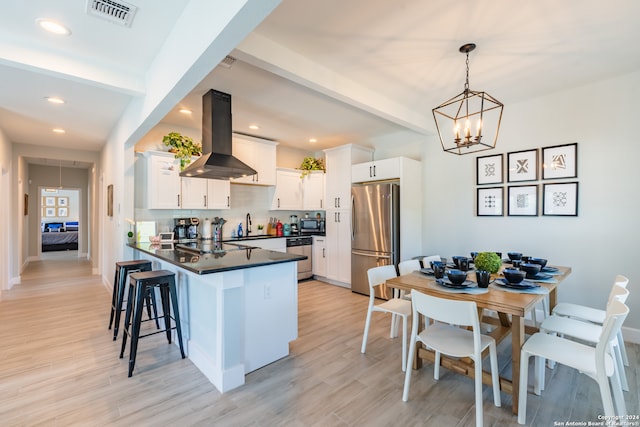 kitchen featuring ventilation hood, decorative light fixtures, light hardwood / wood-style floors, white cabinetry, and stainless steel appliances