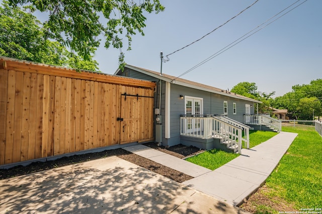 view of front of property featuring a front yard and french doors