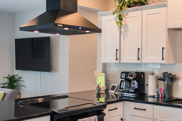 kitchen featuring white cabinets, black range with electric cooktop, wall chimney exhaust hood, and backsplash