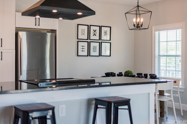 802 Piedmont Ave, San Antonio, TX 78210 - kitchen featuring premium range hood, white cabinetry, a breakfast bar area, freestanding refrigerator, and hanging light fixtures