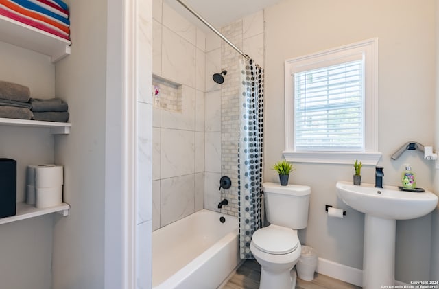 bathroom featuring hardwood / wood-style floors, toilet, and shower / tub combo with curtain