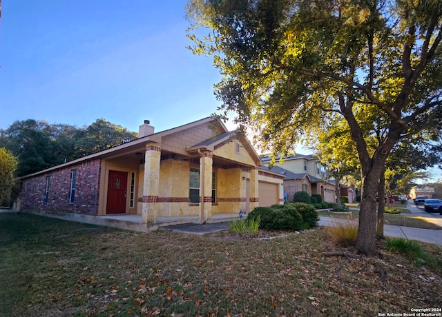 view of front of home with a porch, a garage, and a front lawn