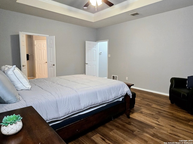 bedroom featuring a tray ceiling, ceiling fan, dark hardwood / wood-style flooring, and ornamental molding