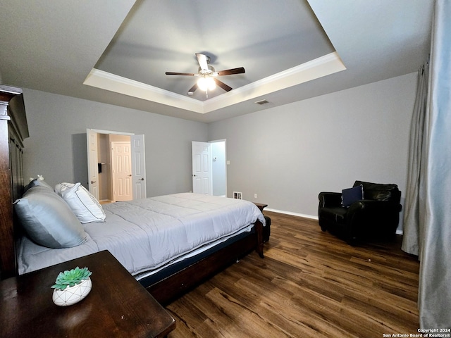 bedroom featuring dark hardwood / wood-style floors, a raised ceiling, and ceiling fan