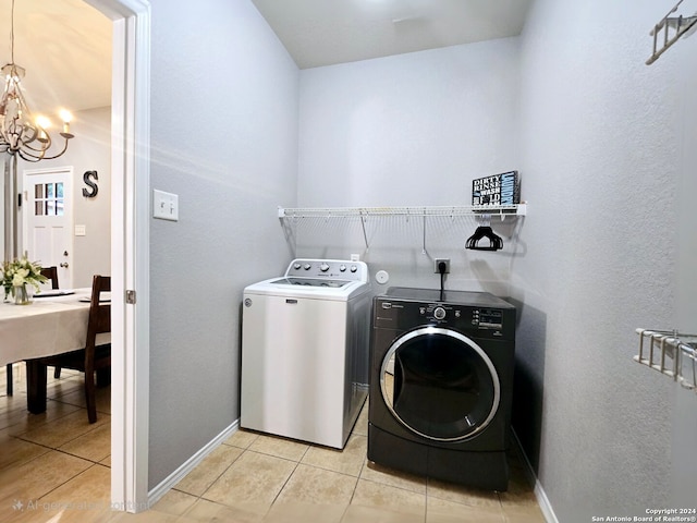 laundry area featuring independent washer and dryer, light tile patterned floors, and an inviting chandelier