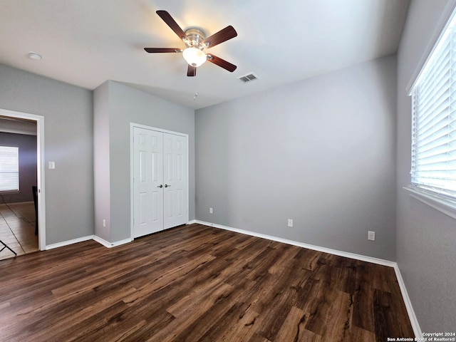 unfurnished bedroom featuring dark hardwood / wood-style flooring, a closet, and ceiling fan