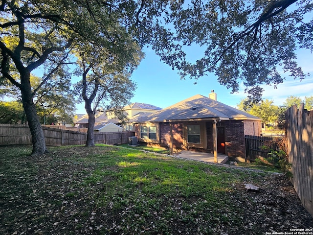 back of house with a lawn and a patio area