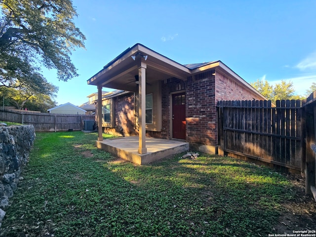 back of property featuring a patio area, ceiling fan, a yard, and central AC