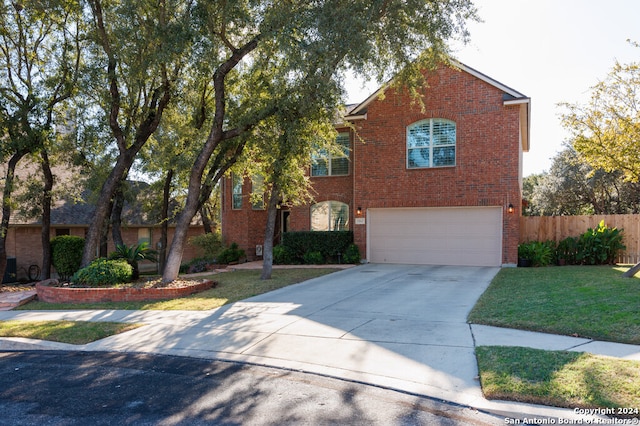 view of property featuring a garage and a front lawn