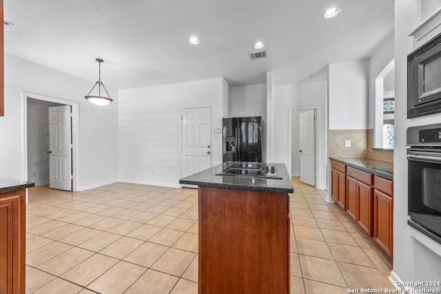 kitchen with a center island, dark stone counters, decorative light fixtures, light tile patterned flooring, and black appliances