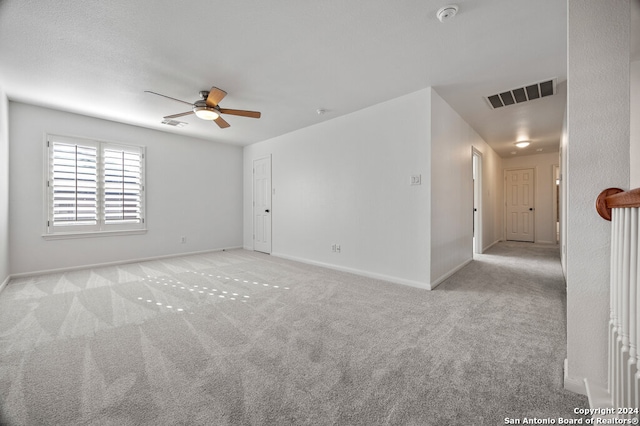 carpeted spare room with ceiling fan