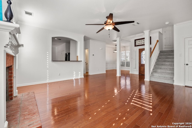 unfurnished living room with crown molding, a fireplace, ceiling fan, and wood-type flooring