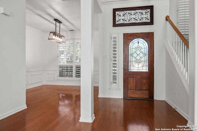 foyer entrance with hardwood / wood-style flooring and ornamental molding