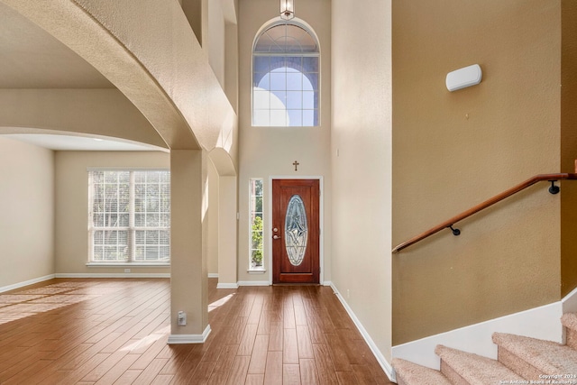 foyer entrance featuring hardwood / wood-style floors and a high ceiling