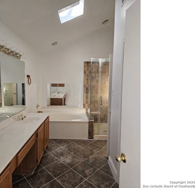 bathroom with tile patterned floors, vanity, lofted ceiling with skylight, and plus walk in shower