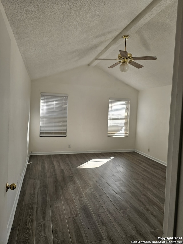 spare room featuring a textured ceiling, ceiling fan, lofted ceiling with beams, and dark hardwood / wood-style floors