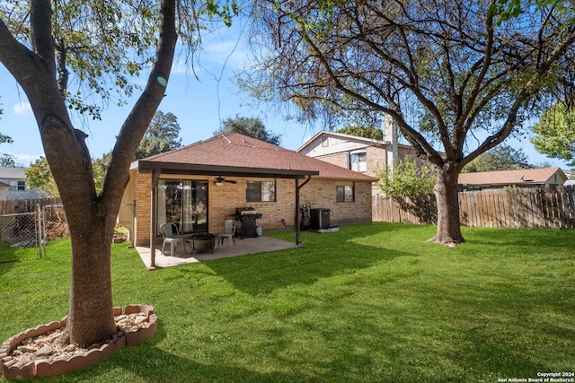 back of property with a lawn, ceiling fan, a patio area, and central AC