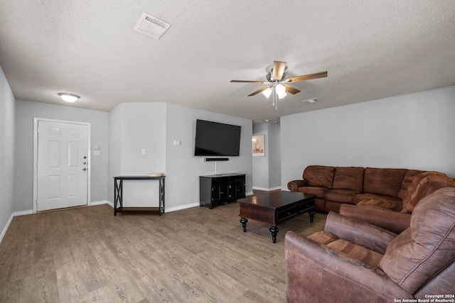 living room featuring hardwood / wood-style floors, ceiling fan, and a textured ceiling