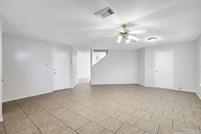 spare room with ceiling fan and light tile patterned flooring