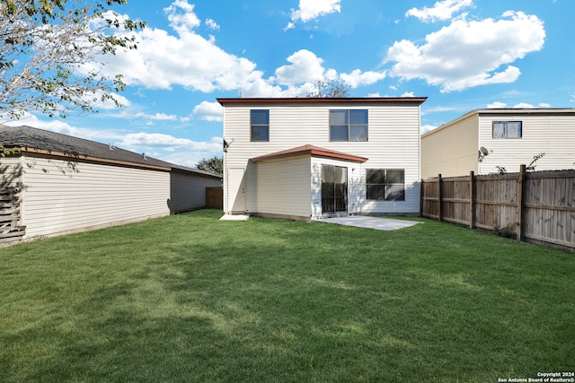 back of property with a lawn and a patio area