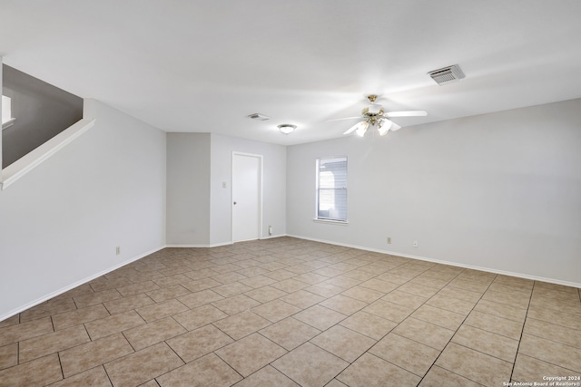 tiled spare room with ceiling fan