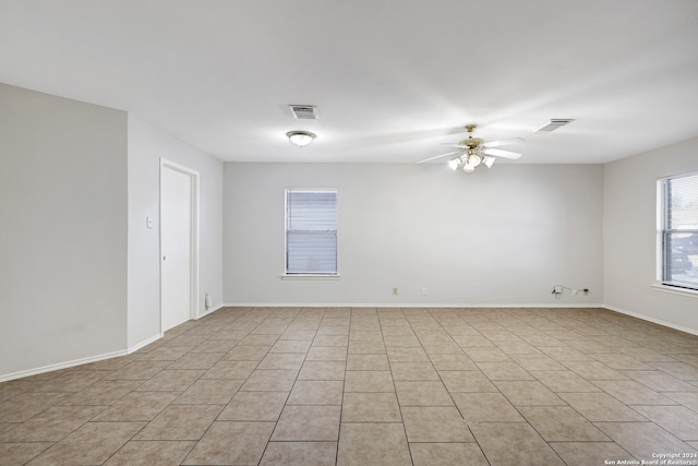 tiled empty room featuring ceiling fan