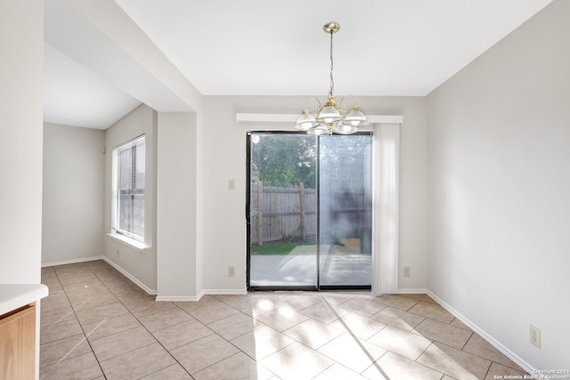 unfurnished dining area with an inviting chandelier and light tile patterned flooring